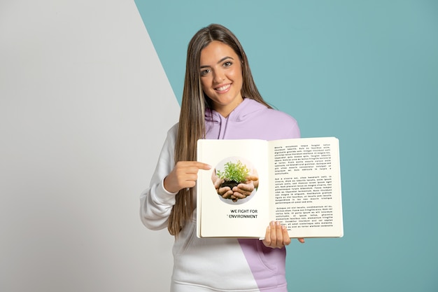 Vista frontale della donna che punta al libro che sta tenendo