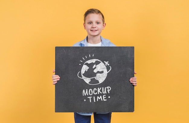 Front view young boy holding mock-up sign