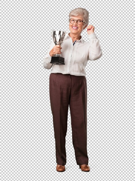 Full body senior woman excited and energetic, raising a trophy