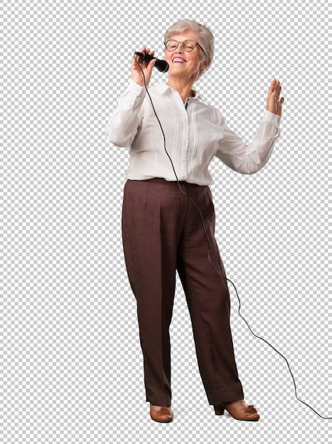 Full body senior woman happy and motivated, singing a song with a microphone, presenting an event or having a party, enjoy the moment