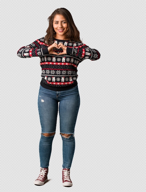 Full body young woman wearing a christmas jersey doing a heart shape with hands