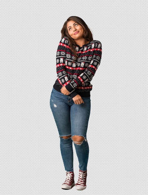 Full body young woman wearing a christmas jersey dreaming of achieving goals and purposes