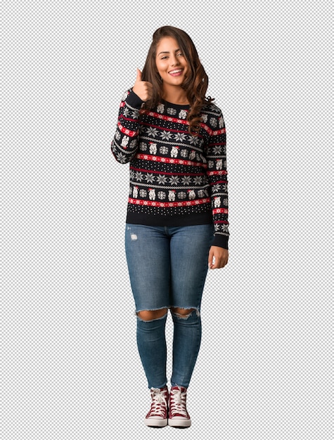 PSD full body young woman wearing a christmas jersey smiling and raising thumb up