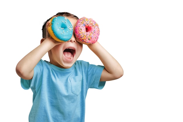 Gelukkige schattige jongen heeft plezier met donuts op png achtergrond heldere foto van een kind