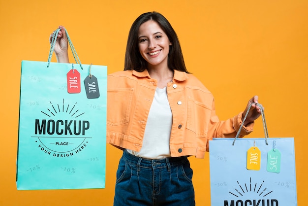 Gelukkige vrouw met boodschappentassen met tags mock-up