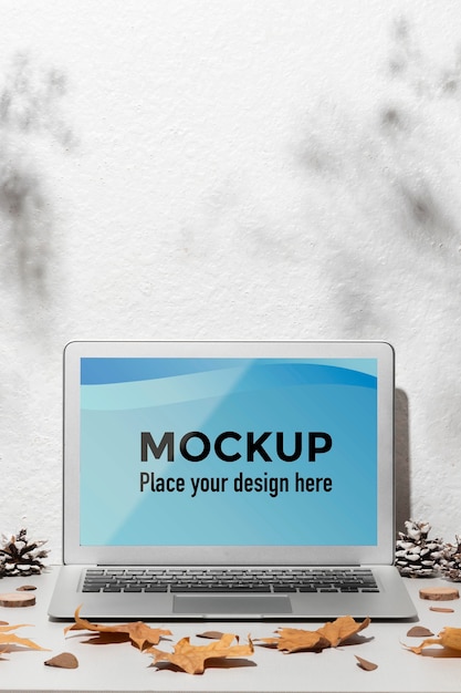 Geopende laptop mockup op tafel omringd door herfstbladeren