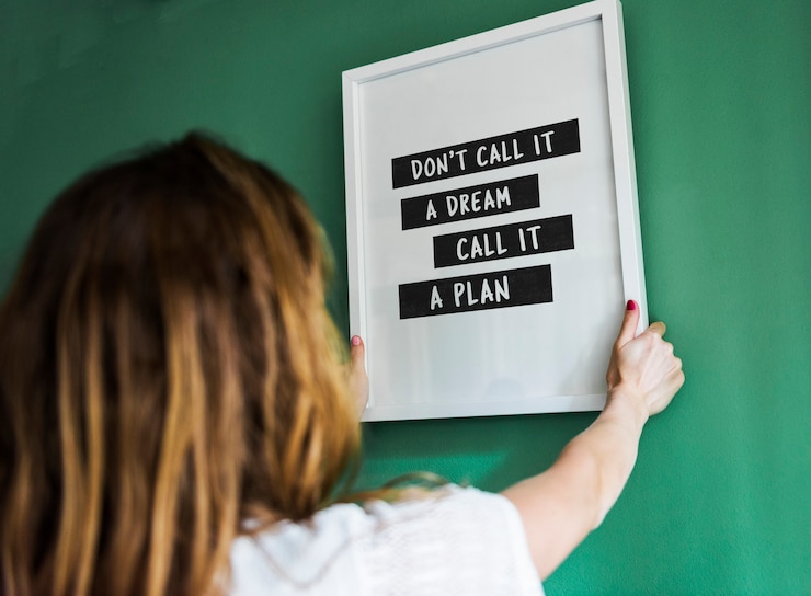 PSD girl hanging a frame on a green wall