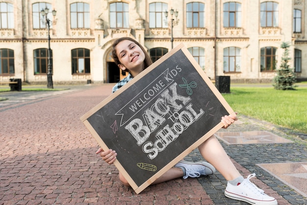 PSD girl holding back to school blackboard mock-up