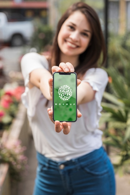 PSD girl holding smartphone mockup with gardening concept