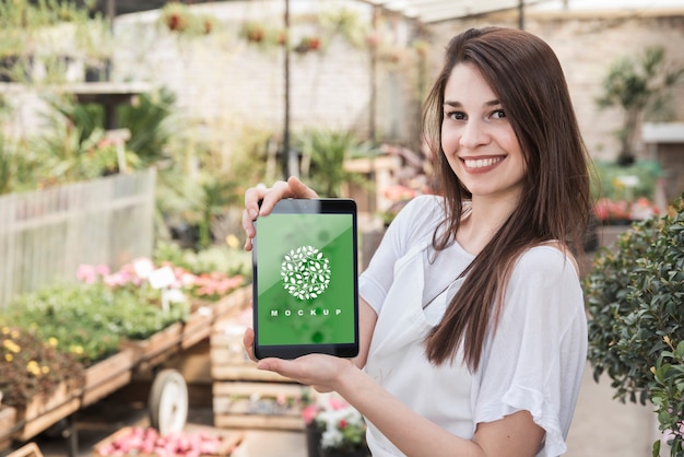 PSD girl holding tablet mockup with gardening concept