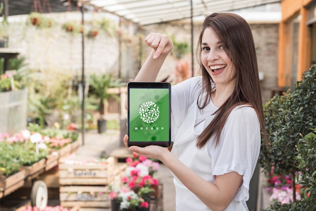 PSD girl holding tablet mockup with gardening concept