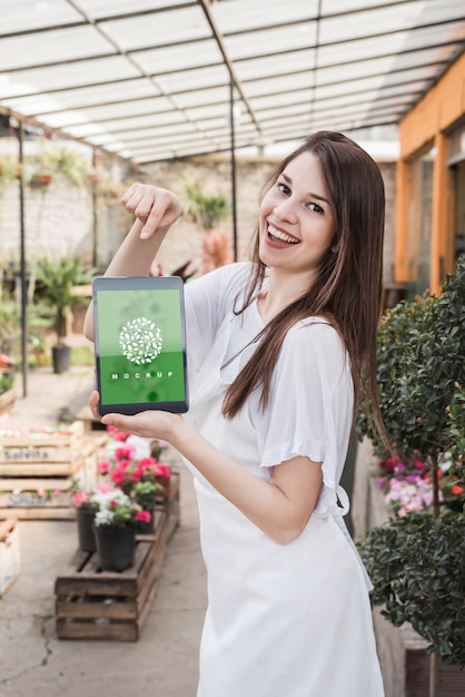 PSD girl holding tablet mockup with gardening concept