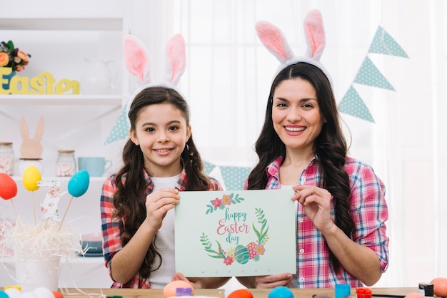 Ragazza e madre con il mockup di carta il giorno di pasqua