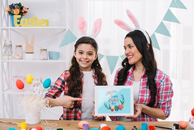 PSD ragazza e madre con il modello di tablet sul giorno di pasqua