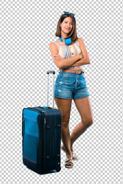 Girl traveling with her suitcase keeping the arms crossed in frontal position. Confident expression