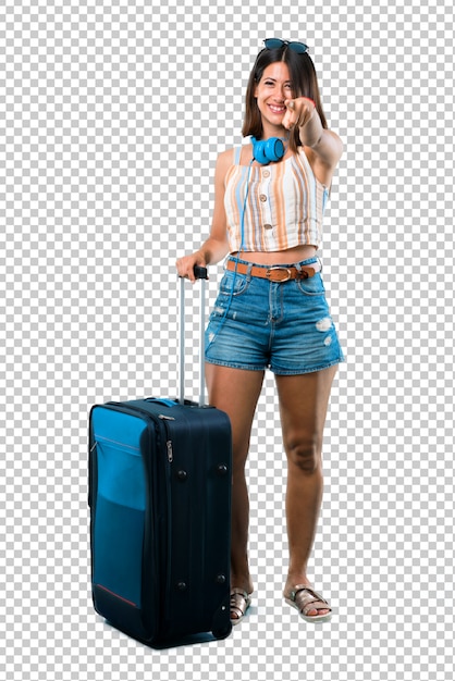 PSD girl traveling with her suitcase points finger at you with a confident expression