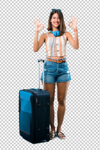 Girl traveling with her suitcase showing an ok sign with fingers. Face of happiness and satisfaction