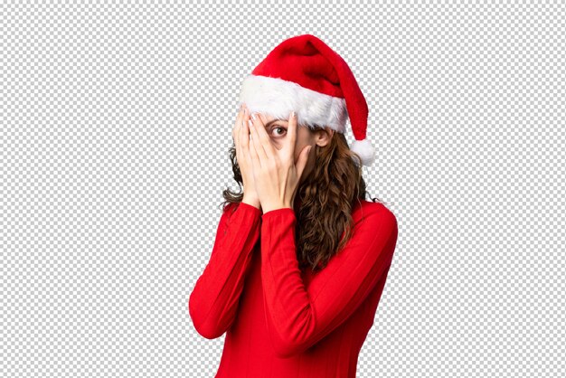 PSD Девушка с шляпой рождества покрывая глаза и смотря сквозь пальцы
