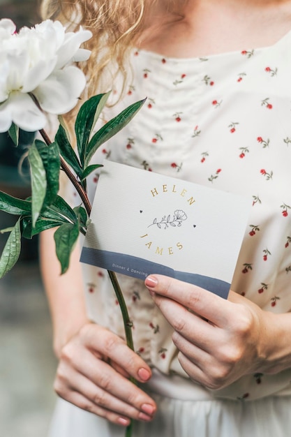 Girl with a white paeonia snowboard flower and a mockup card