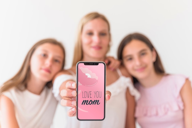 Girls presenting smartphone mockup for mothers day