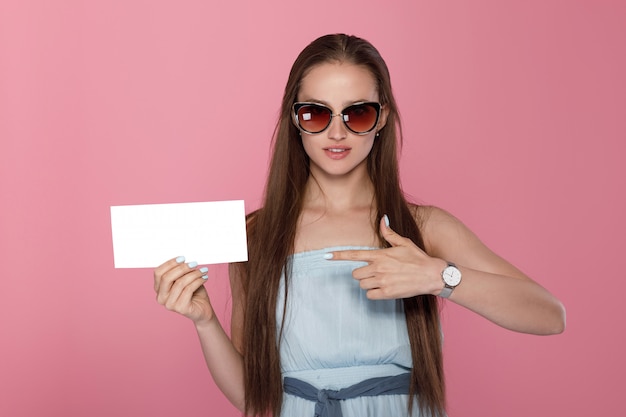 Glimlachende vrolijke leuke jonge vrouw die lege lege banner toont