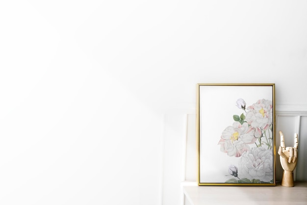 Gold photo frame by the hand mannequin on a white table