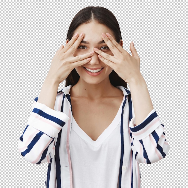 PSD 麗で魅力的で友好的な若い女性ストライプのブラウスを着て手のひらで目を覆い指を通ってき込み広々と微笑んでいます
