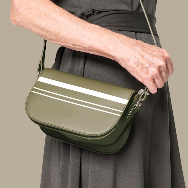 Psd макет зеленой сумки через плечо с полосатой женской одеждой