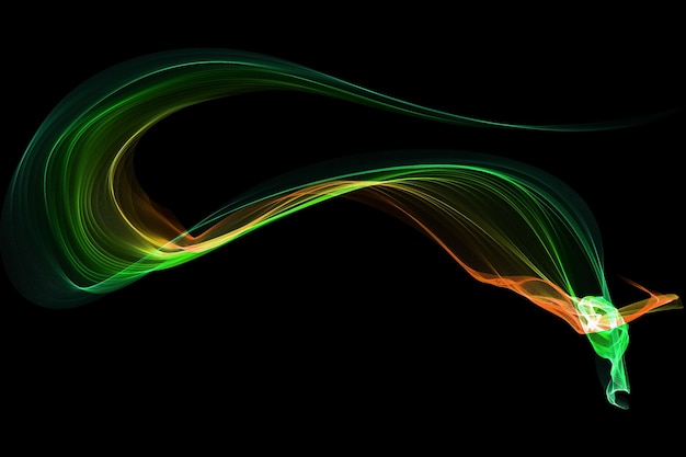 Green and orange smoke in motion on a black background