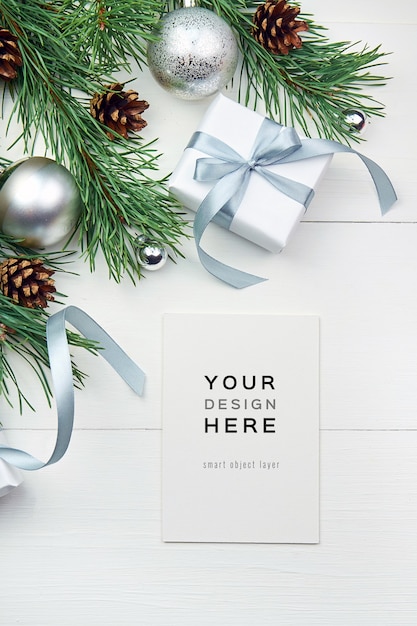 Greeting card mockup with christmas decorations on white wooden background