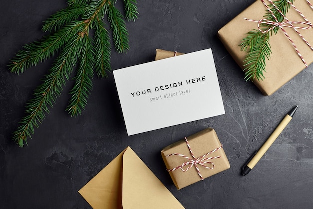 어둠에 크리스마스 선물 상자와 전나무 나무 가지와 인사말 카드 모형
