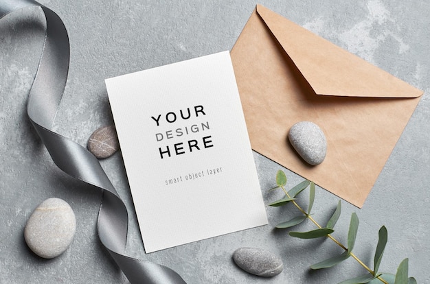 greeting card mockup with envelope, eucalyptus twig and grey stones