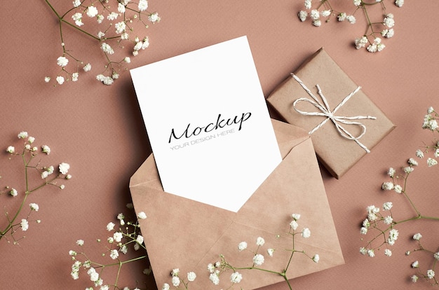 Greeting card mockup with envelope, gift box and white hypsophila flowers