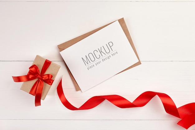 Greeting card mockup with gift box and red ribbon 