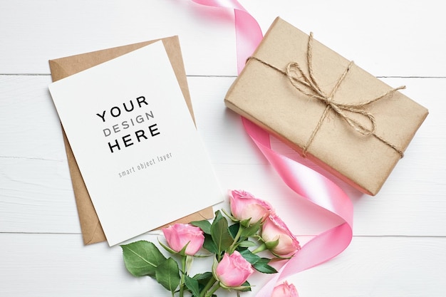 Mockup di biglietto di auguri con scatola regalo e fiori di rose