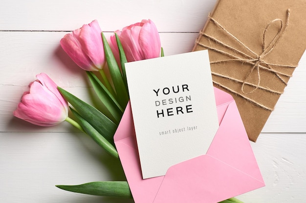 Greeting card mockup with pink envelope, gift box and tulip flowers