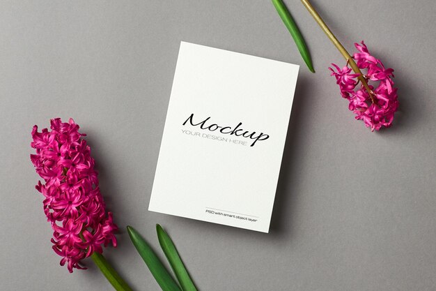 Mockup di biglietto di auguri con fiori di giacinto primaverile su carta grigia