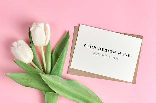 Mockup di biglietto di auguri con bouquet di fiori di tulipano bianco su sfondo rosa