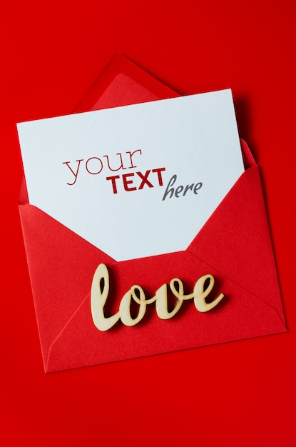 Greeting card for Valentine's Day. Red envelope with blank white paper. Mockup of love letter.