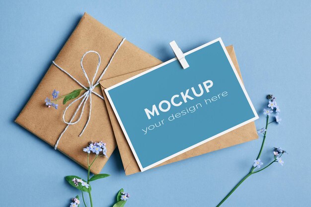 Mockup di biglietto vuoto o invito con regalo e fiori