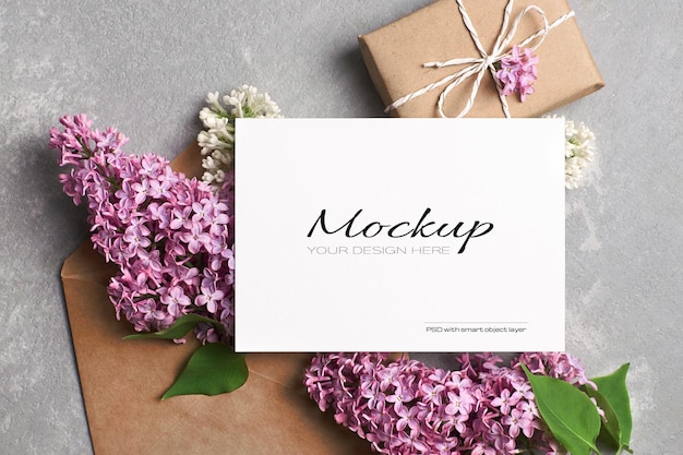 Greeting or invitation card mockup with gift box, envelope and spring lilac flowers