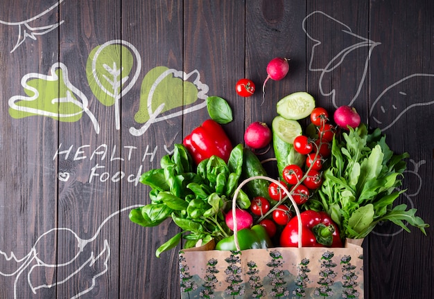 Grocery bag full of vegetables on a wooden surface