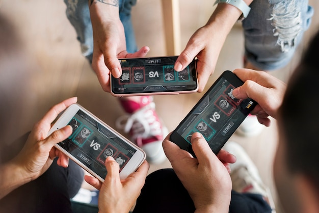 group of diverse friends playing game on mobile phone
