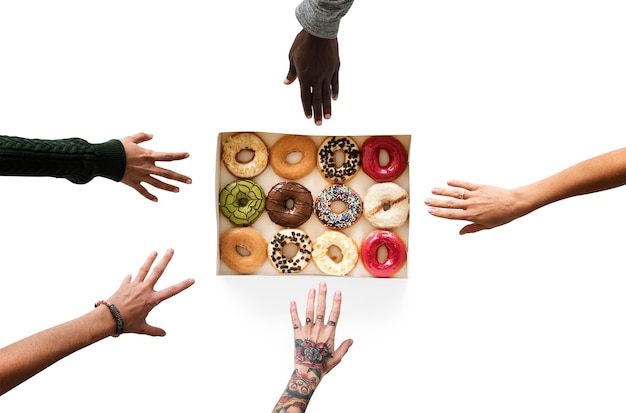 도넛 디저트를 도달하는 손의 그룹