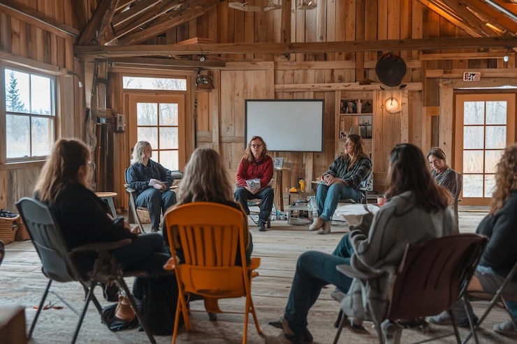 PSD group of women seated in a circle in a rustic barn listening to a presentation