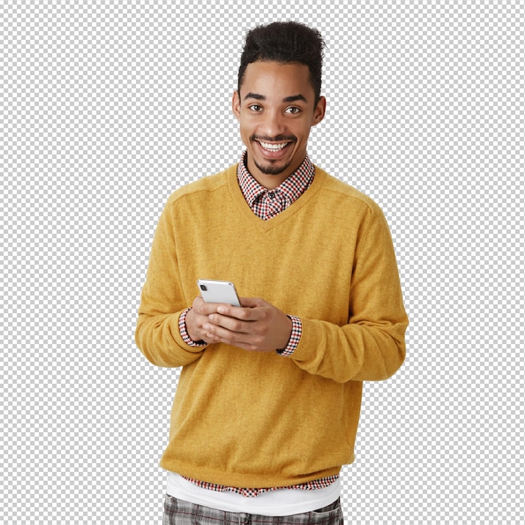 PSD guy wants to make call indoor shot of pleased handsome africanamerican male model with afro haircut in yellow sweater holding smartphone smiling broadly while messaging with friend