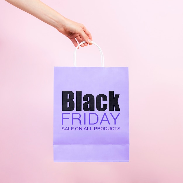 Hand holding a black friday paper bag