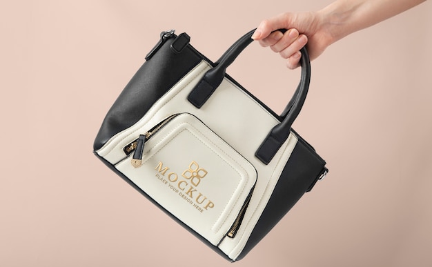 PSD hand holding black and white handbag