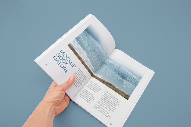 Hand holding book mockup