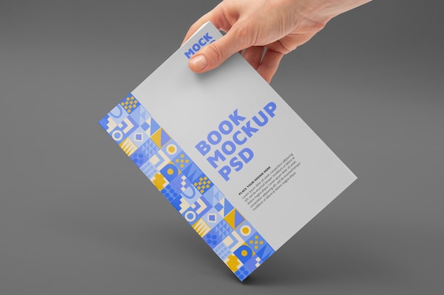 PSD hand holding book mockup